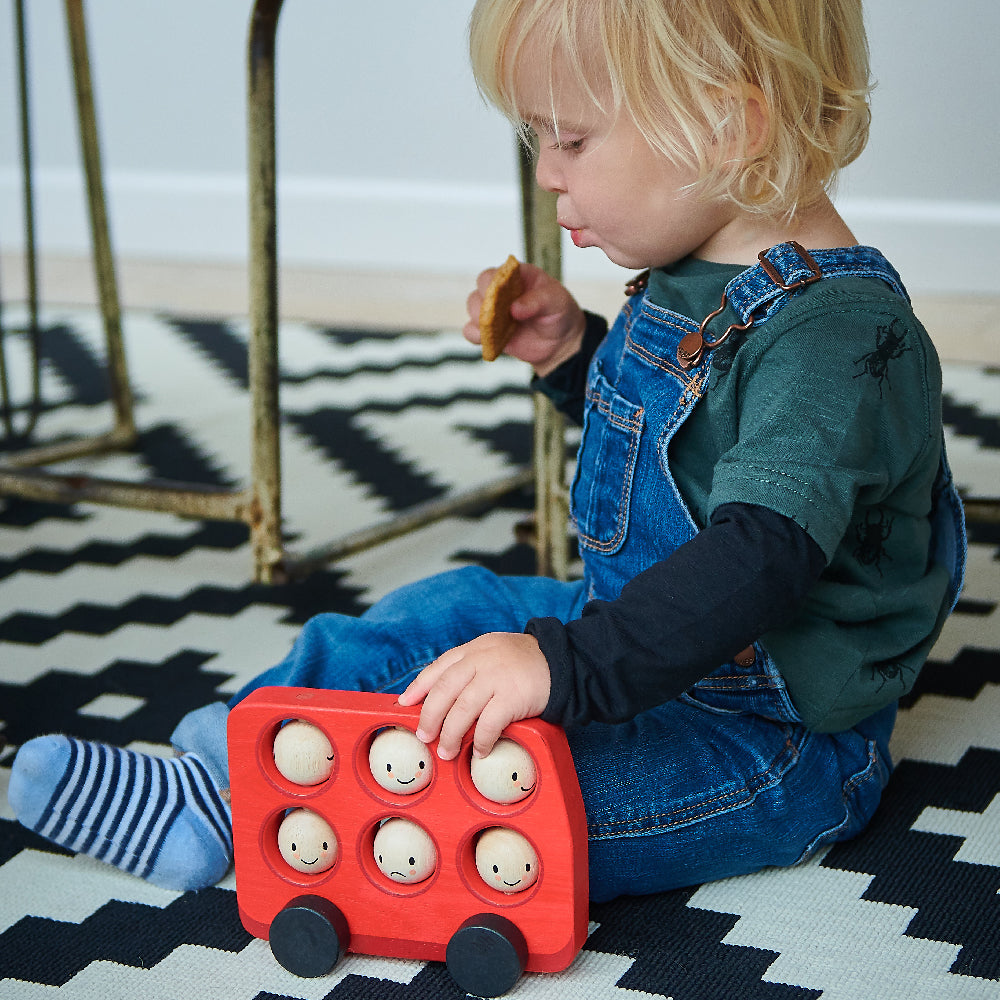 Tender Leaf Toys wooden red bus for toddlers with 6 smiley rotating faces